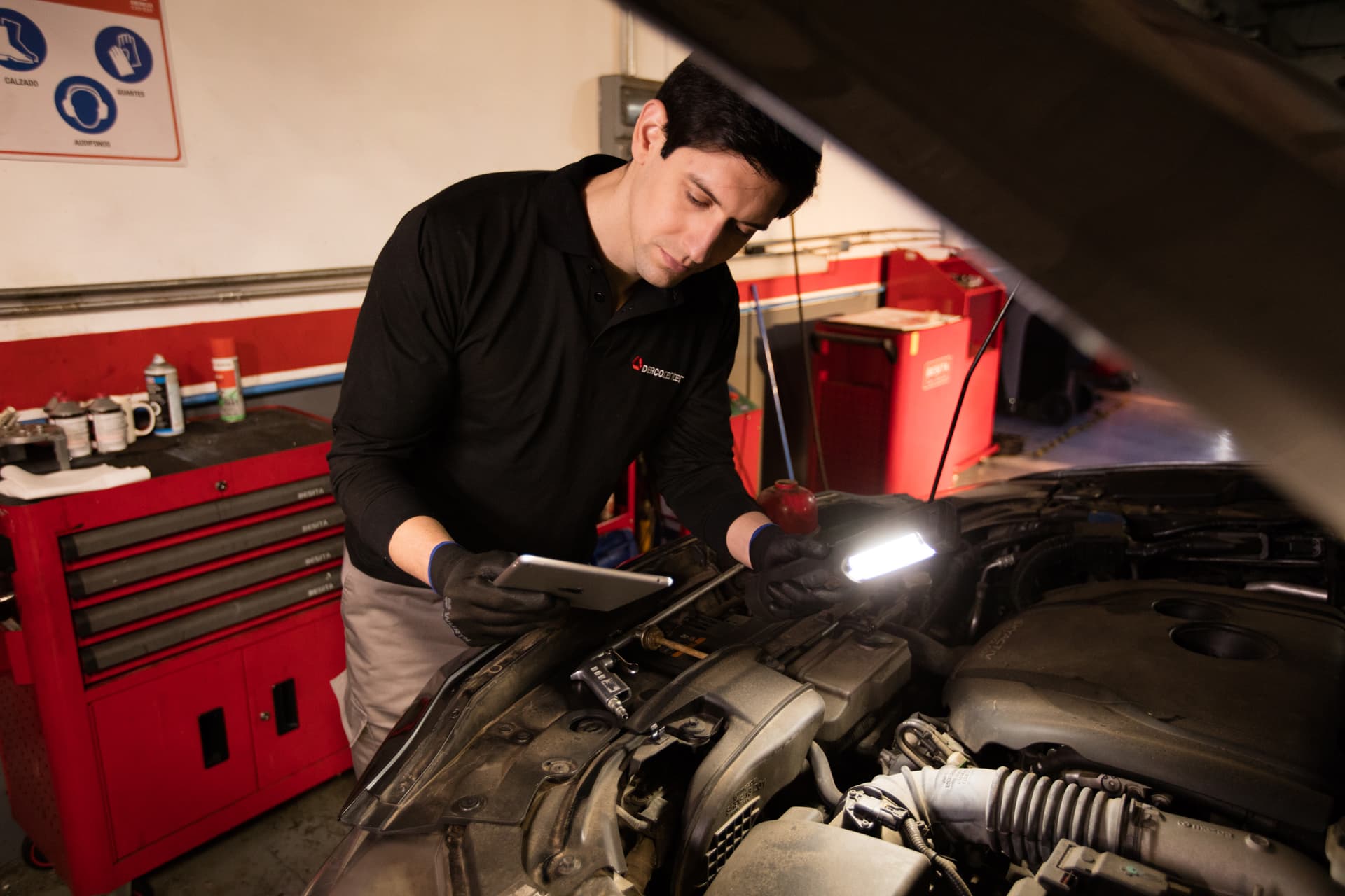 Mecánico revisando motor en taller autorizado